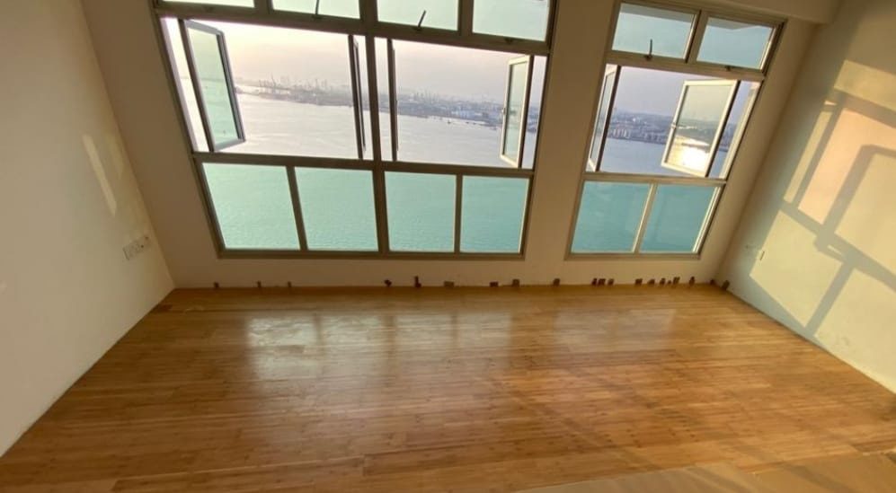 Natural-tone strand bamboo flooring installed across a sea-view condominium living room in Singapore